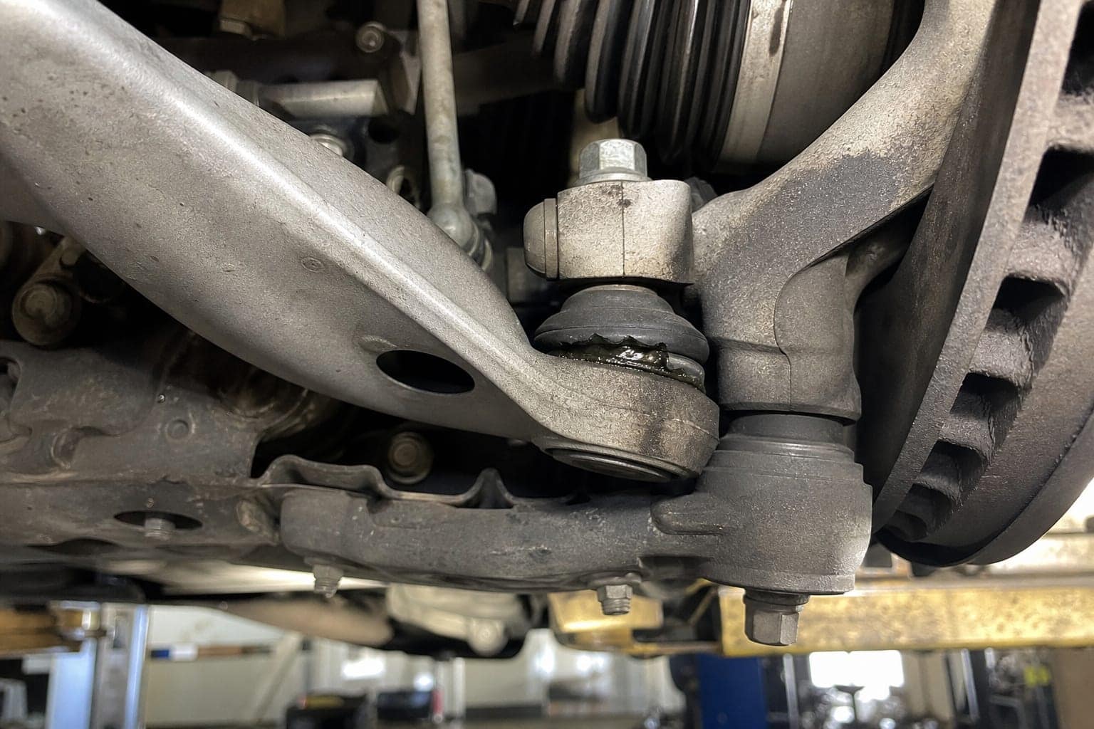 Detailed inspection of a vehicle suspension component and torn ball joint boot